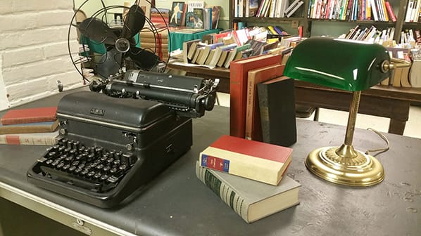 typewriter, lamp, and books on desk